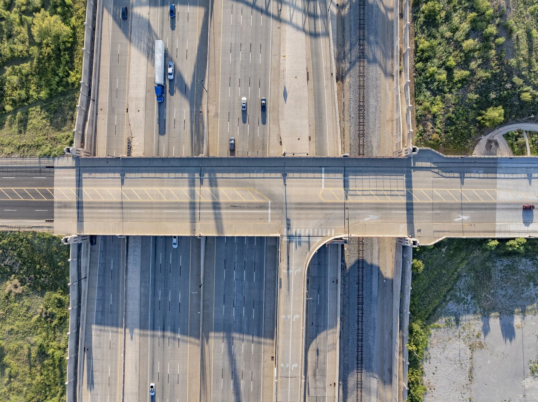 Overhead view of an overpass crossing a multi lane interstate, with traffic moving beneath